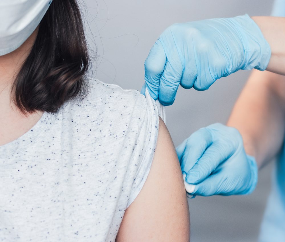 nurse hands in medical gloves using cotton before make injection to patient in a medical mask. Concept of coronavirus vaccination